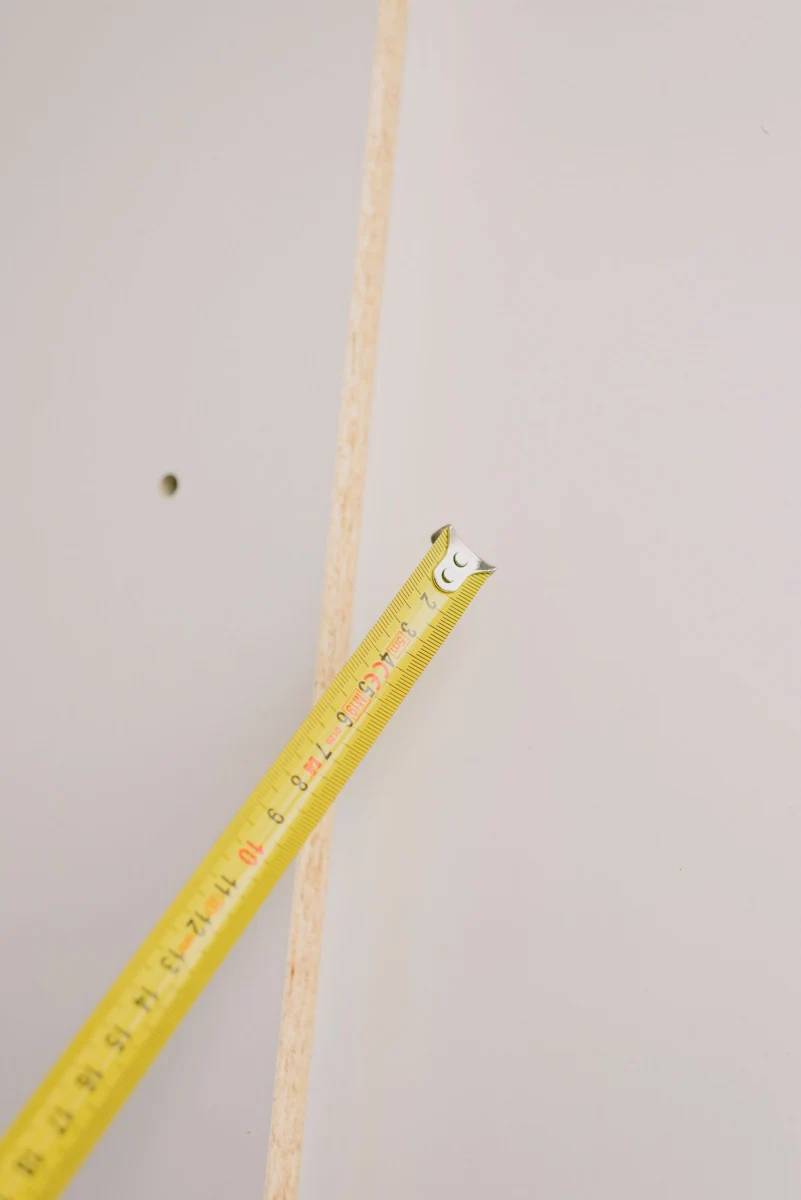 捲尺與板材的丈量情境；不是實際缺失證據，也不是本文案例的現場照片。